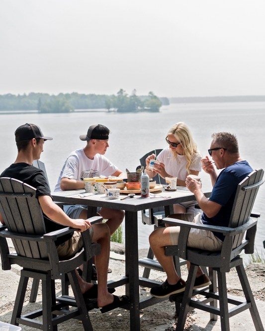 family sitting by the lake at a tall table in Kawartha Lakes